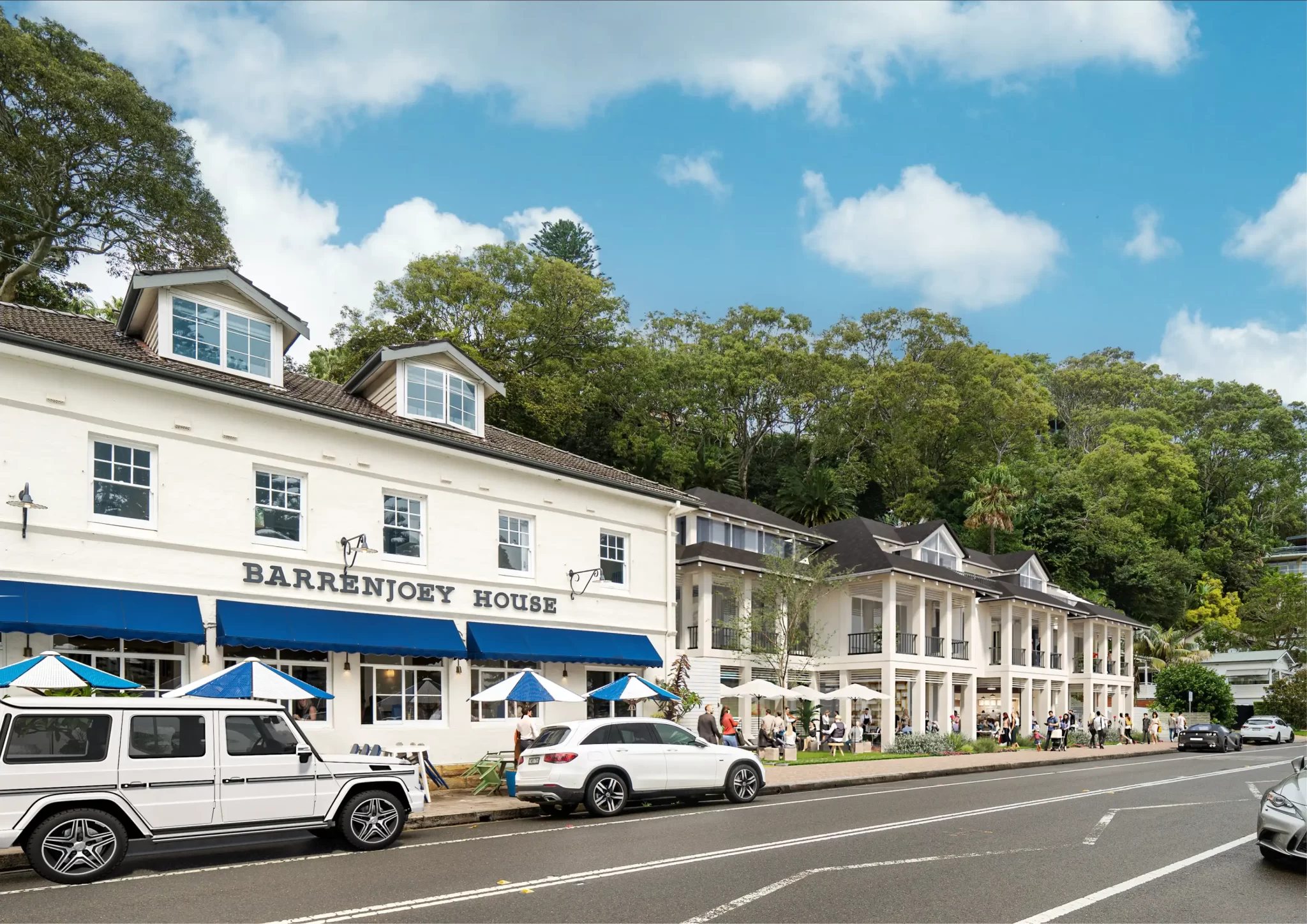 Street view of Barrenjoey House and adjacent buildings in Palm Beach, surrounded by trees with cars parked along the roadside and people enjoying the outdoor seating.