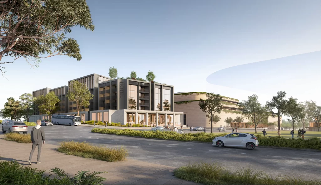 Render of a modern mixed-use development featuring a six-storey hotel with rooftop greenery and a retail complex surrounded by landscaped greenery and pedestrians walking along a tree-lined street.