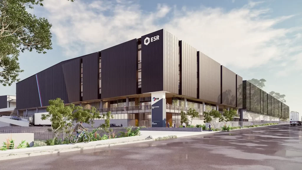 A modern, multi-level warehouse with a sleek black façade, large ESR branding, and a landscaped entrance. The facility features elevated loading docks, ramp access for trucks, and a pedestrian-friendly pathway with greenery. The sky is partly cloudy, and the road appears wet, reflecting the surrounding environment.