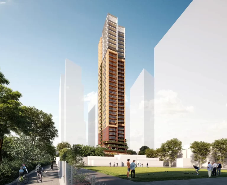 A 35-storey mixed-use high-rise development in Chatswood, featuring a contemporary brick and glass façade with greenery integrated into the podium. The tower is set against a bright blue sky, with pedestrians and cyclists on a pathway and people playing lawn bowls in the foreground.