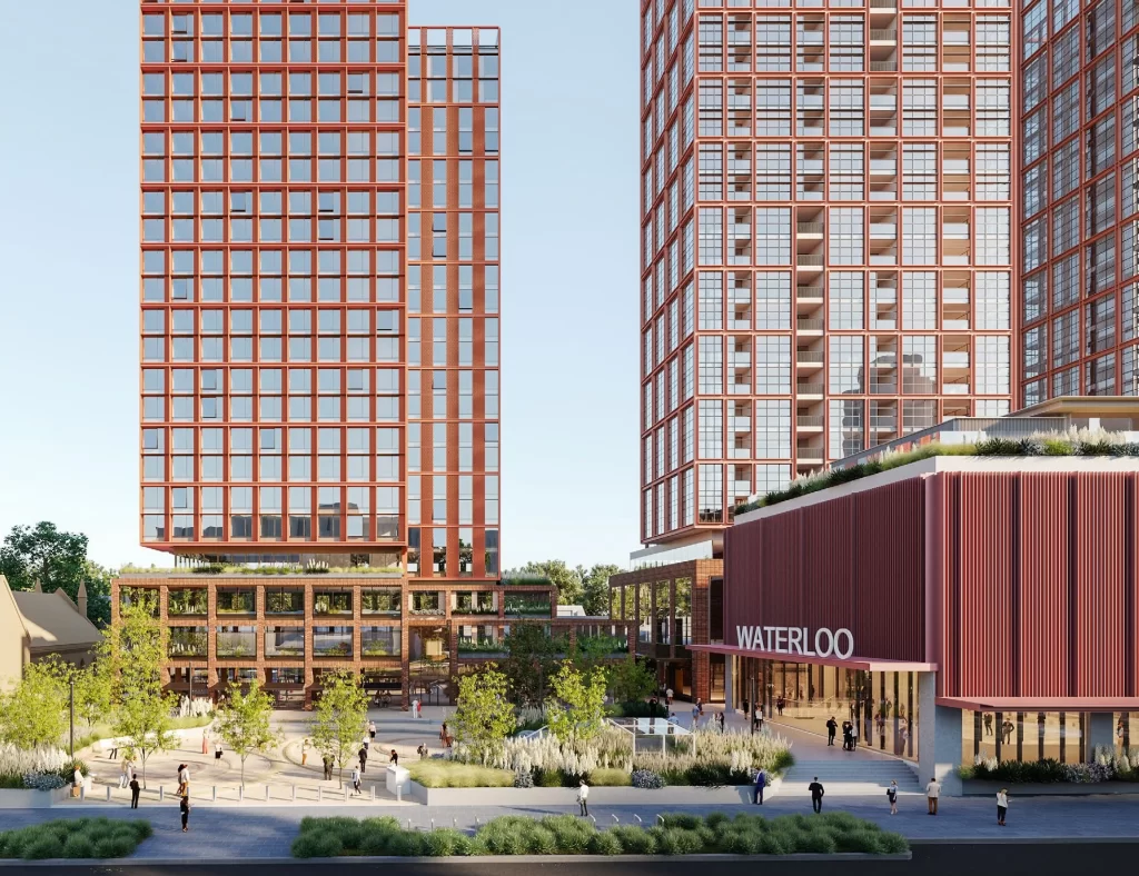 Architectural rendering of the proposed Waterloo Metro Quarter redevelopment, featuring two high-rise residential towers with a modern red-brick facade. The development includes a landscaped public plaza, pedestrian walkways, and a retail podium with a prominent "Waterloo" sign at the entrance.