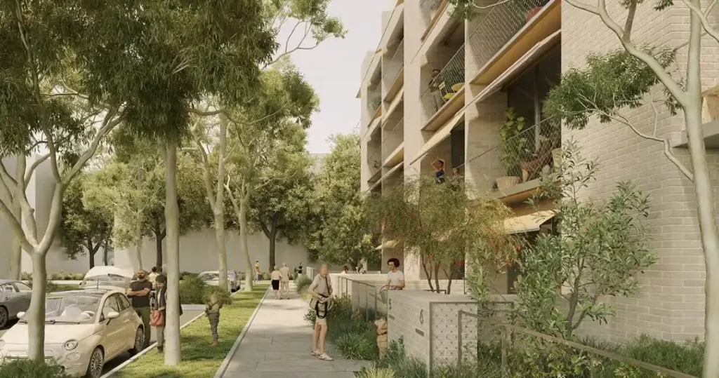 A tree-lined residential street with a modern low-rise apartment building featuring balconies with greenery. People are walking along the footpath, engaging in daily activities, and interacting with their surroundings. The scene highlights a pedestrian-friendly urban environment with ample green space.