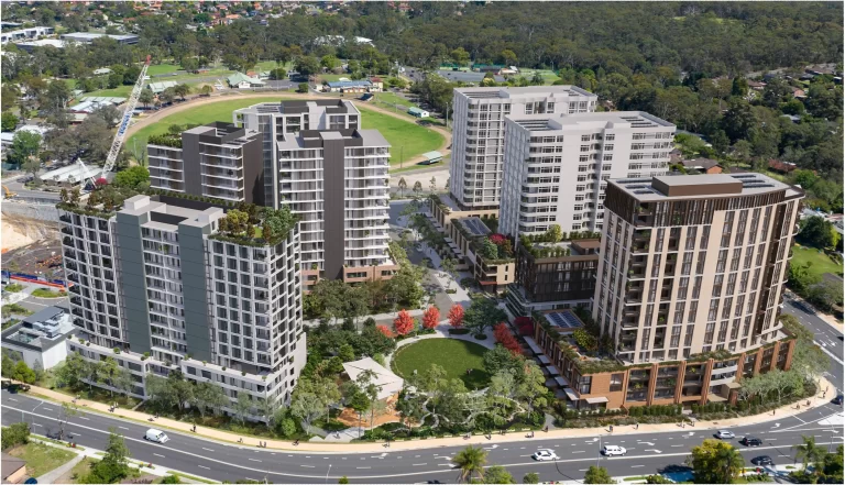 Aerial view of a proposed high-density residential development at Showground Station Precinct East in Castle Hill. The image showcases five modern apartment buildings ranging from mid-rise to high-rise, featuring rooftop gardens, landscaped communal spaces, and a central public park. Surrounding infrastructure includes major roads, pedestrian pathways, and a nearby construction site. In the background, a green open space with a sports field and low-density housing is visible.