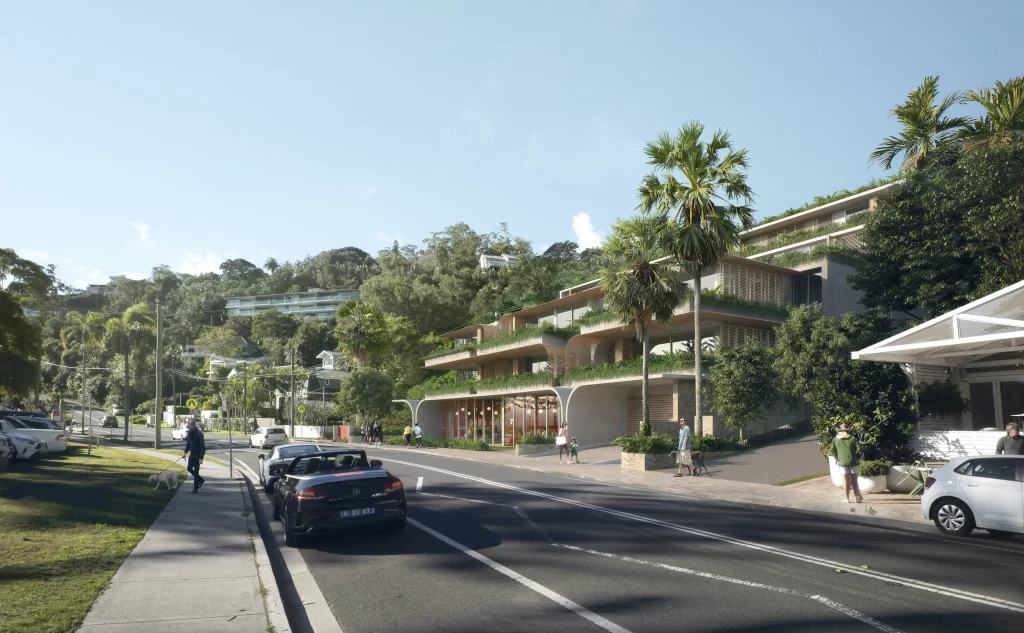 A rendered image of a proposed shop-top housing development at 1112–1116 Barrenjoey Road, Palm Beach. The design features a modern, terraced structure with curved concrete elements, extensive greenery, and open balconies. The ground floor includes retail spaces with large glass windows. The building is integrated into a lush hillside setting, surrounded by trees and coastal vegetation. Pedestrians walk along the footpath, while cars, including a black convertible, are parked along the road.