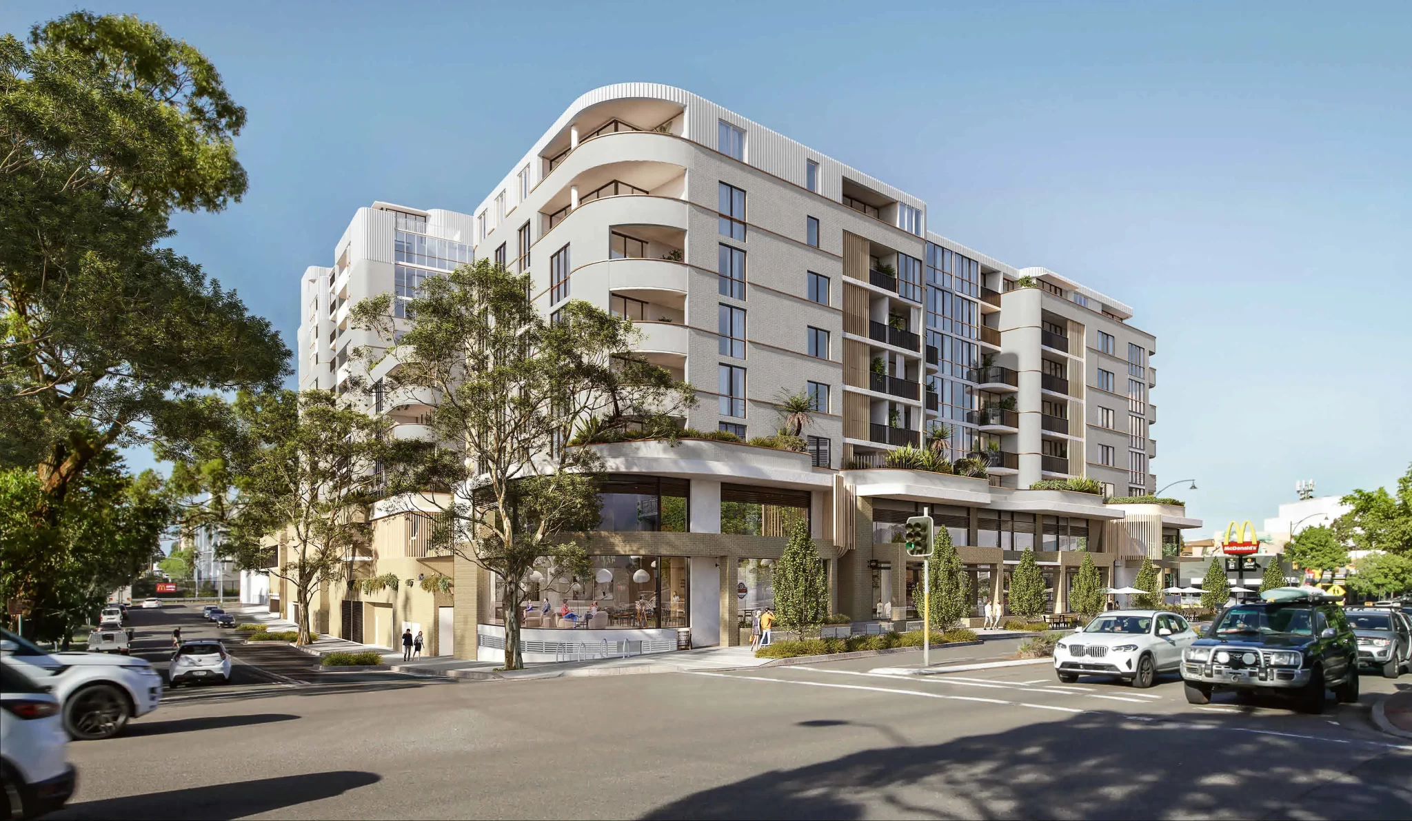 Render of a mixed-use residential building above a retail podium in Caringbah, showing street-level shops and apartment balconies.