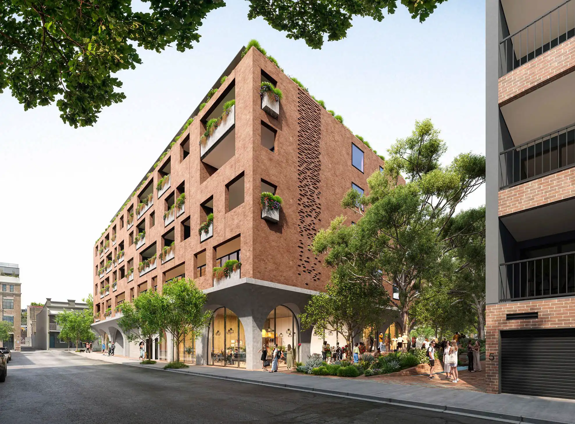 Street-level perspective of a six-storey mixed-use building with red brick façade, arched ground-floor retail frontages, and landscaped public space with people gathering.