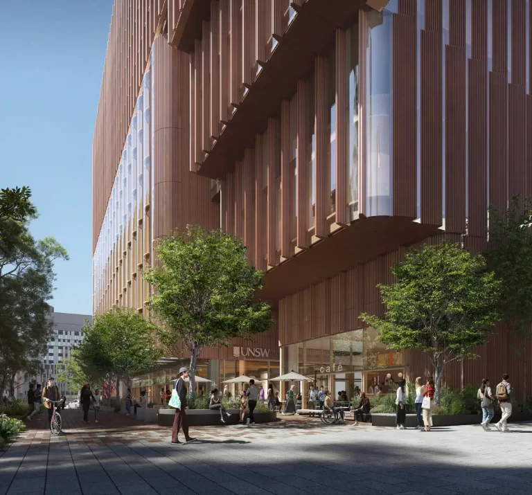 People walk and sit beneath trees outside a proposed UNSW education building with a tall, terracotta-coloured facade and vertical fins.