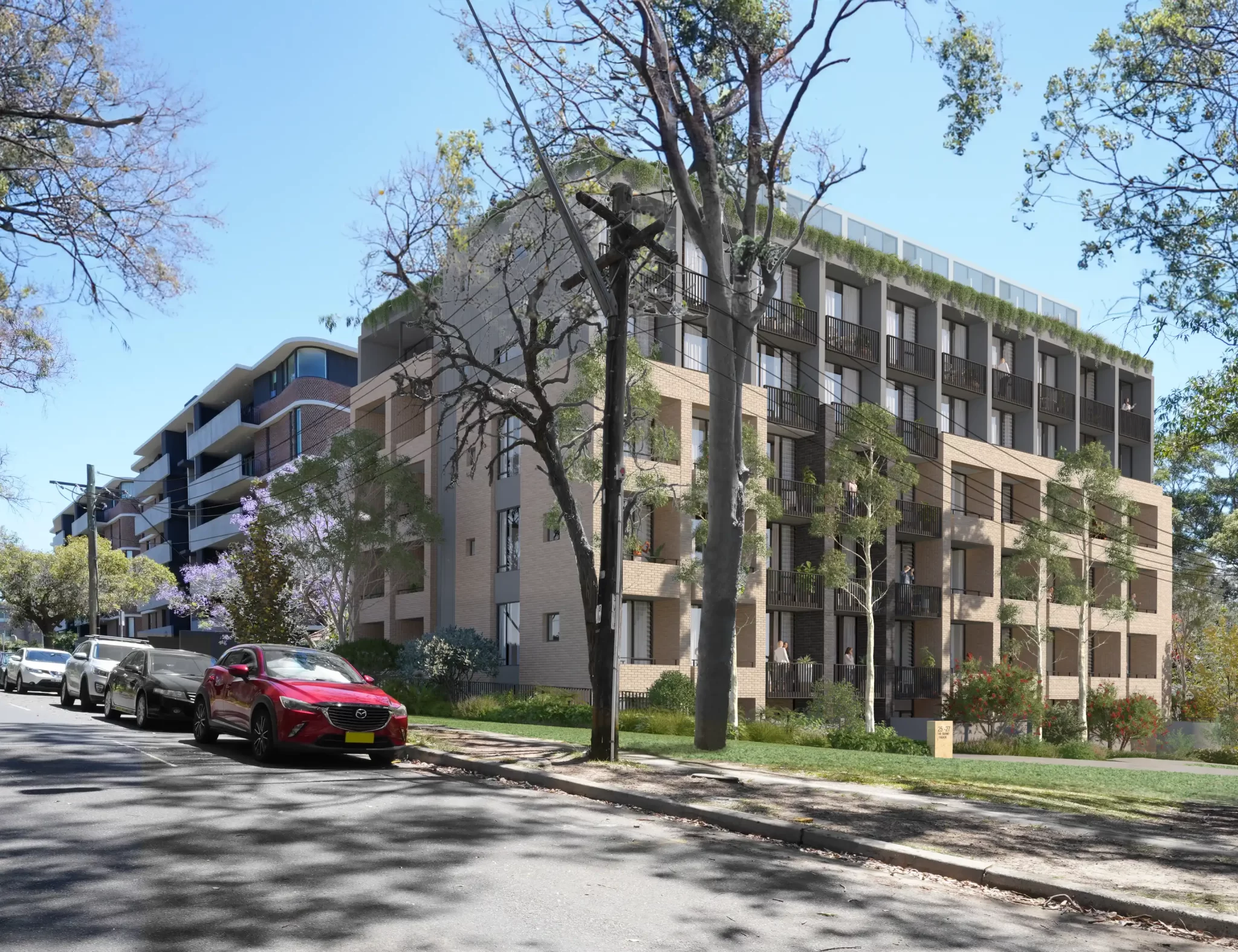 A rendered image of a proposed six-storey residential building on The Grand Parade, Sutherland. The building features modern architectural design with balconies, greenery, and surrounding trees. The scene includes parked cars and a well-maintained streetscape.