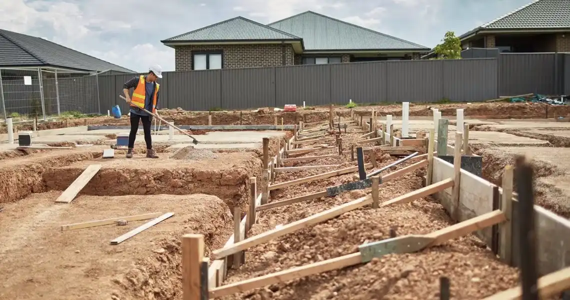 Construction worker prepares residential housing foundation on a development site in suburban New South Wales.