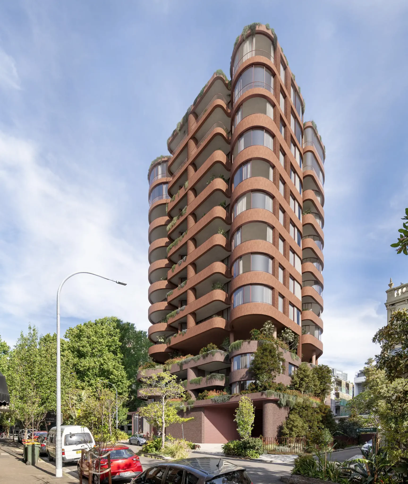 Artist’s rendering of a terracotta-coloured, multi-storey apartment tower with curved balconies and planted terraces on a tree-lined street corner.